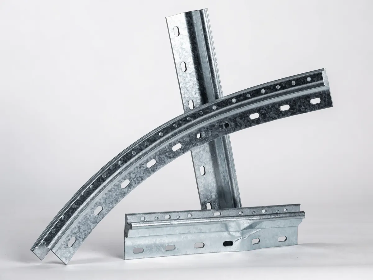 Garage door track sections crossing, a curved radius piece and a straight vertical piece with punched bolt slots, plus a horizontal piece with a dent and a bend